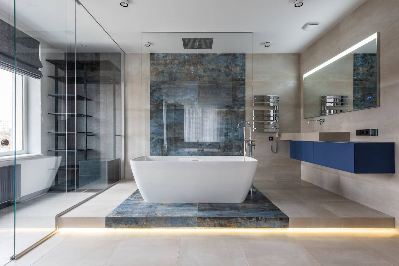 bathtub in a bathroom with blue and black tiles